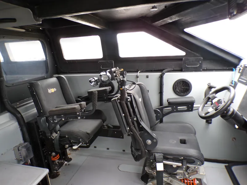 Slide: The Image of Interior of a 2001 Custom Revenge 50 boat, featuring advanced seating and control systems. - 9