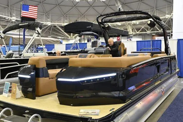The Image of 2025 Princecraft Vogue 25 RL pontoon boat displayed at an indoor boat show. - 1