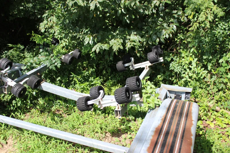 Slide: The Image of Boat trailer for 1998 Sea Ray 210 Sundeck surrounded by lush greenery. - 28