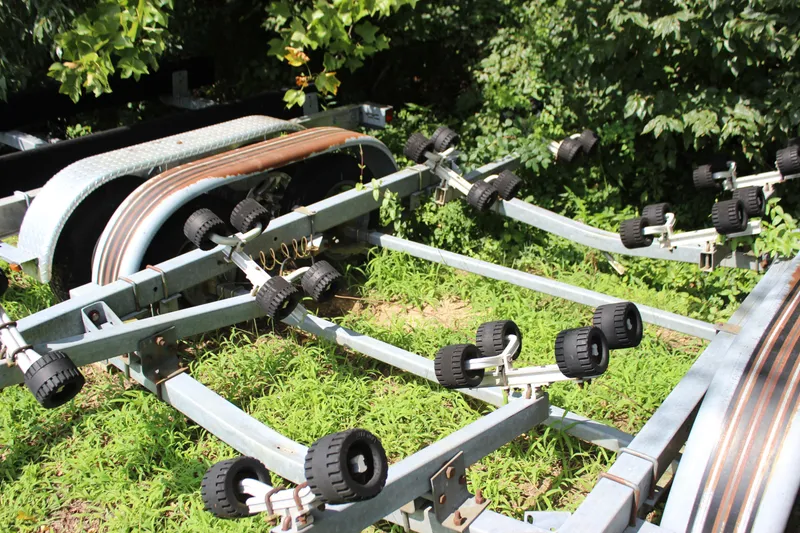 Slide: The Image of Boat trailer for 1998 Sea Ray 210 Sundeck, parked on grass, surrounded by greenery. - 31
