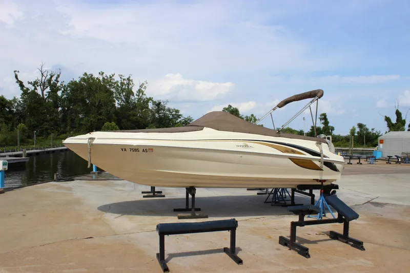 The Image of 1998 Sea Ray 210 Sundeck boat on a lift at a marina. - 1