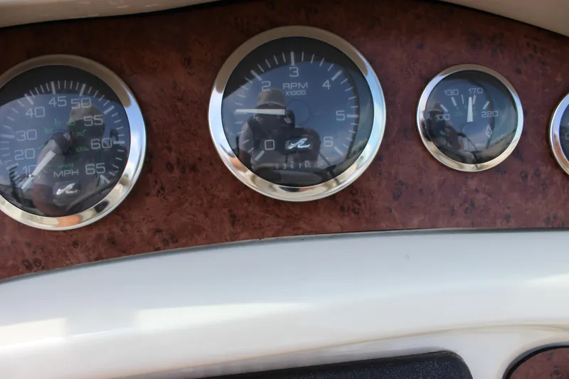Slide: The Image of Dashboard gauges of a 1998 Sea Ray 210 Sundeck boat. - 12