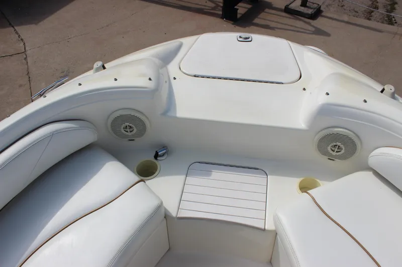 Slide: The Image of 1998 Sea Ray 210 Sundeck boat interior with white seating and built-in speakers. - 18