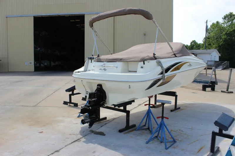 Slide: The Image of 1998 Sea Ray 210 Sundeck boat on stands outside a large storage facility. - 3