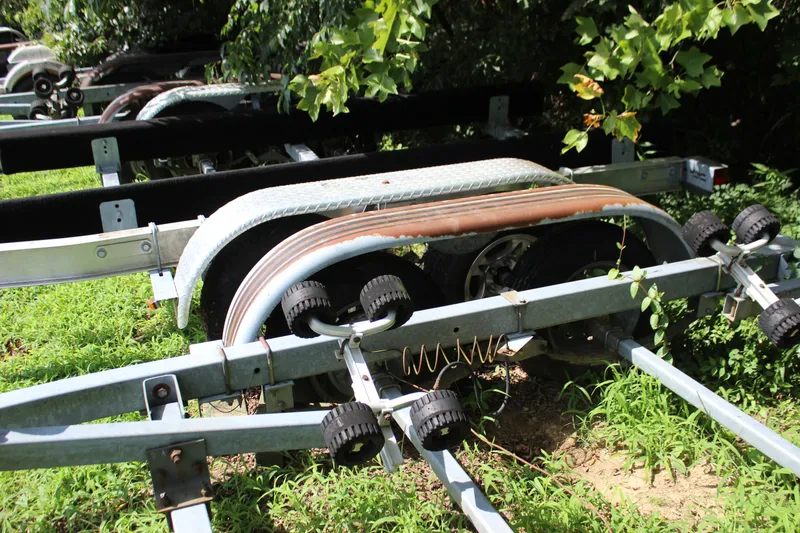 Slide: The Image of Boat trailer for 1998 Sea Ray 210 Sundeck, parked on grass with surrounding greenery. - 27