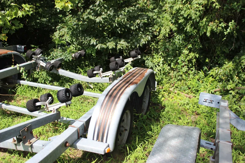 Slide: The Image of Boat trailer for 1998 Sea Ray 210 Sundeck, surrounded by lush greenery. - 25