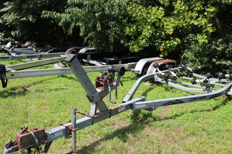 Slide: The Image of Boat trailers on grass, suitable for 1998 Sea Ray 210 Sundeck, surrounded by greenery. - 23