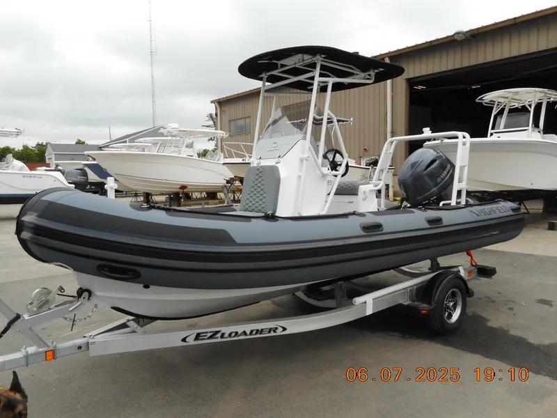 The Image of 2025 Highfield Patrol 540 boat on EZ Loader trailer, parked outdoors. - 0