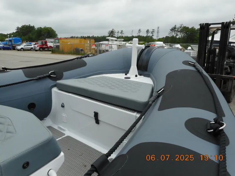 Slide: The Image of 2025 Highfield Patrol 540 boat interior with seating and storage, docked outdoors. - 2