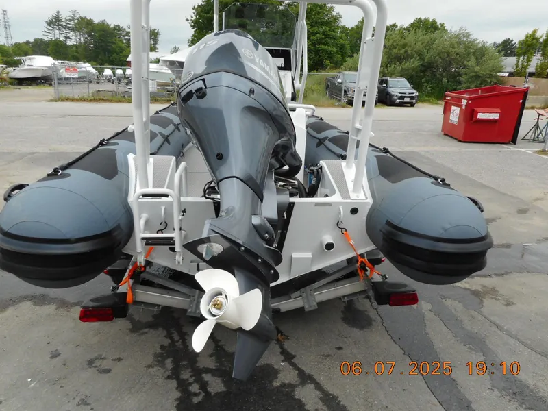 Slide: The Image of 2025 Highfield Patrol 540 boat with outboard motor, parked outdoors. - 5