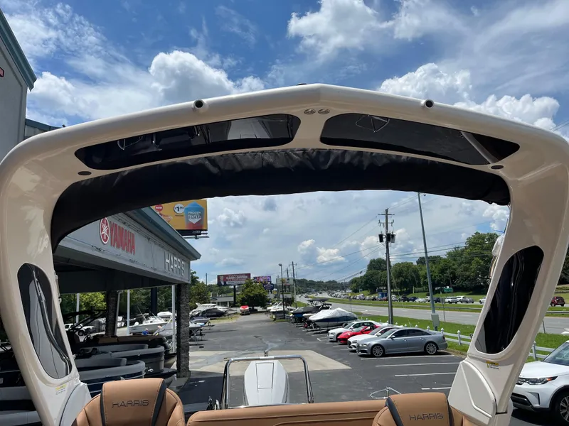 Slide: The Image of 2026 Harris Grand Mariner 250 boat at dealership, under a sunny sky. - 14