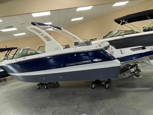 Slide: The Image of 2025 Chaparral 247 SSX boat displayed in a showroom with award banners. - 2
