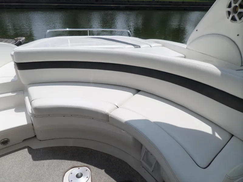 Slide: The Image of 2005 Sea Ray 290 SS boat with white curved seating and water view. - 13