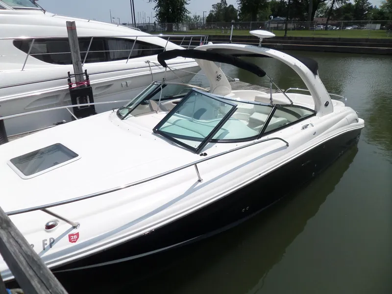 Slide: The Image of 2005 Sea Ray 290 SS boat docked in a marina, featuring sleek design and white exterior. - 2