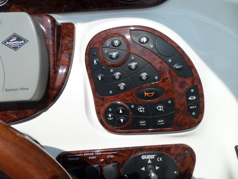 Slide: The Image of Control panel of a 2005 Sea Ray 290 SS boat with wood finish and various buttons. - 22