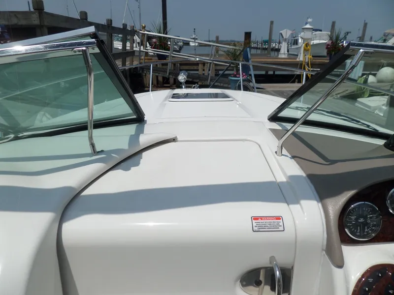Slide: The Image of 2005 Sea Ray 290 SS boat dashboard with open windshield, docked at marina. - 29