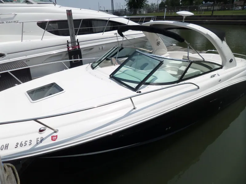 Slide: The Image of 2005 Sea Ray 290 SS boat docked in marina, sleek design, white and black exterior. - 3