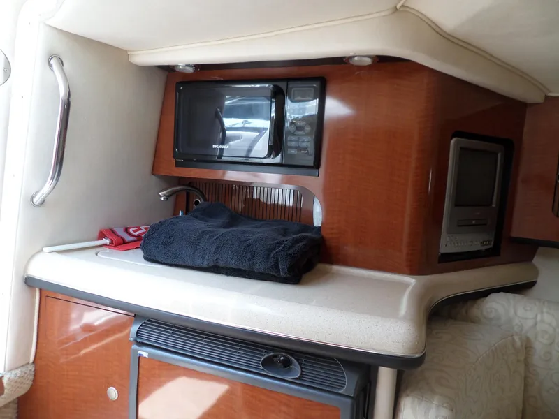 Slide: The Image of 2005 Sea Ray 290 SS cabin interior with microwave and wooden cabinetry. - 31