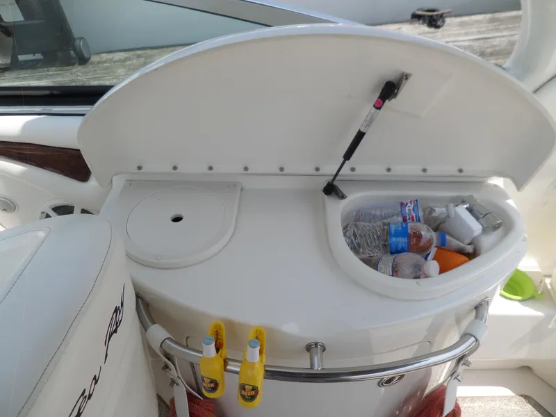 Slide: The Image of 2005 Sea Ray 290 SS boat interior with open storage compartment and beverages. - 41