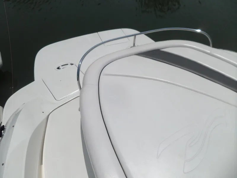 Slide: The Image of 2005 Sea Ray 290 SS boat deck, white upholstery, sleek design, and stainless steel railing. - 49