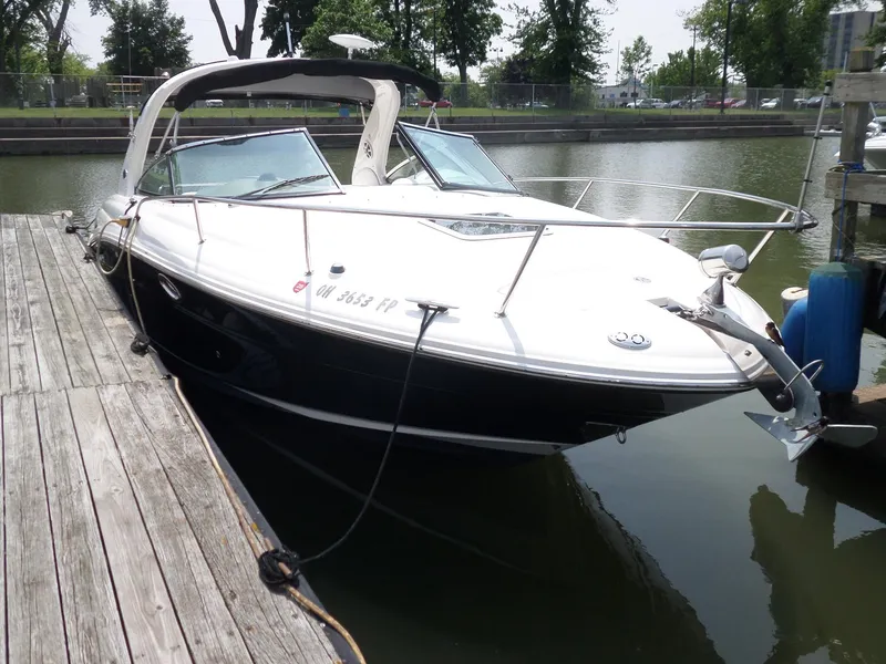 Slide: The Image of 2005 Sea Ray 290 SS boat docked on calm water, surrounded by trees. - 5