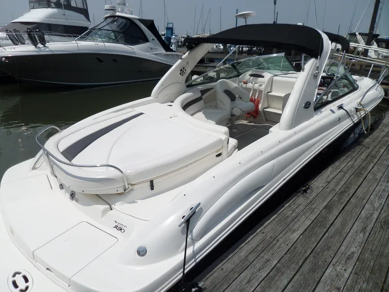 Slide: The Image of 2005 Sea Ray 290 SS boat docked at marina, featuring sleek white design and spacious seating. - 7