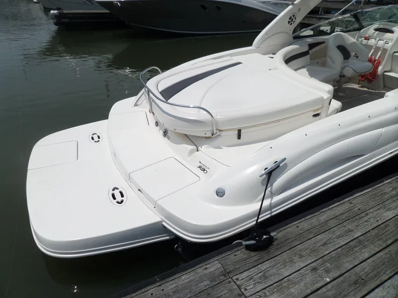 Slide: The Image of 2005 Sea Ray 290 SS boat docked, featuring sleek white design and spacious seating. - 8