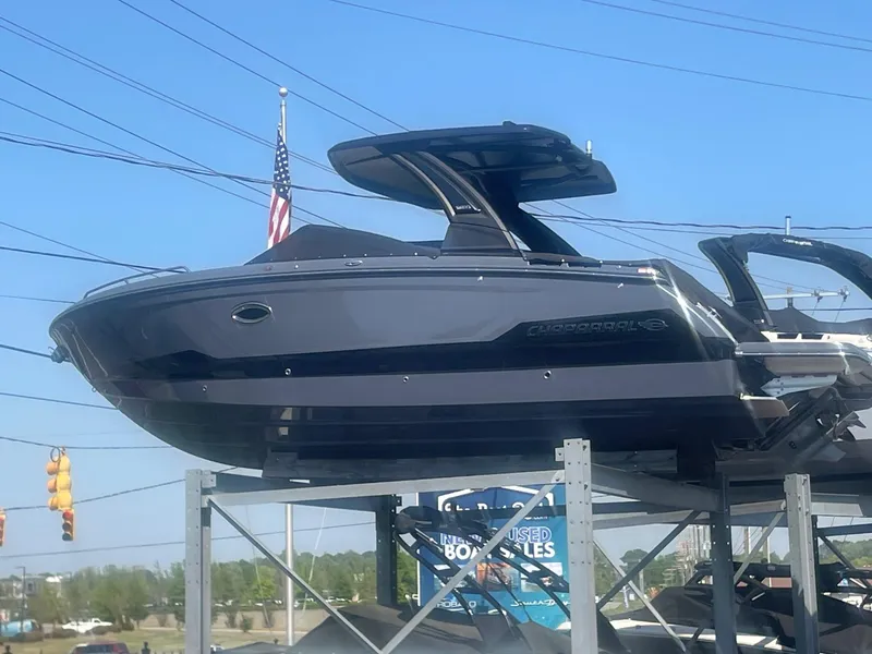 The Image of 2025 Chaparral 2870 boat displayed on a rack with an American flag in the background. - 0