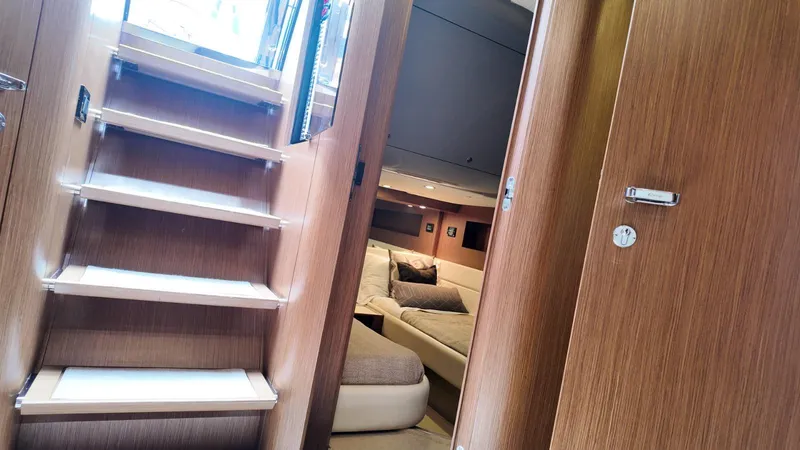 Slide: The Image of Interior of 2012 Riva Rivale yacht, featuring wooden stairs and a cozy cabin. - 47