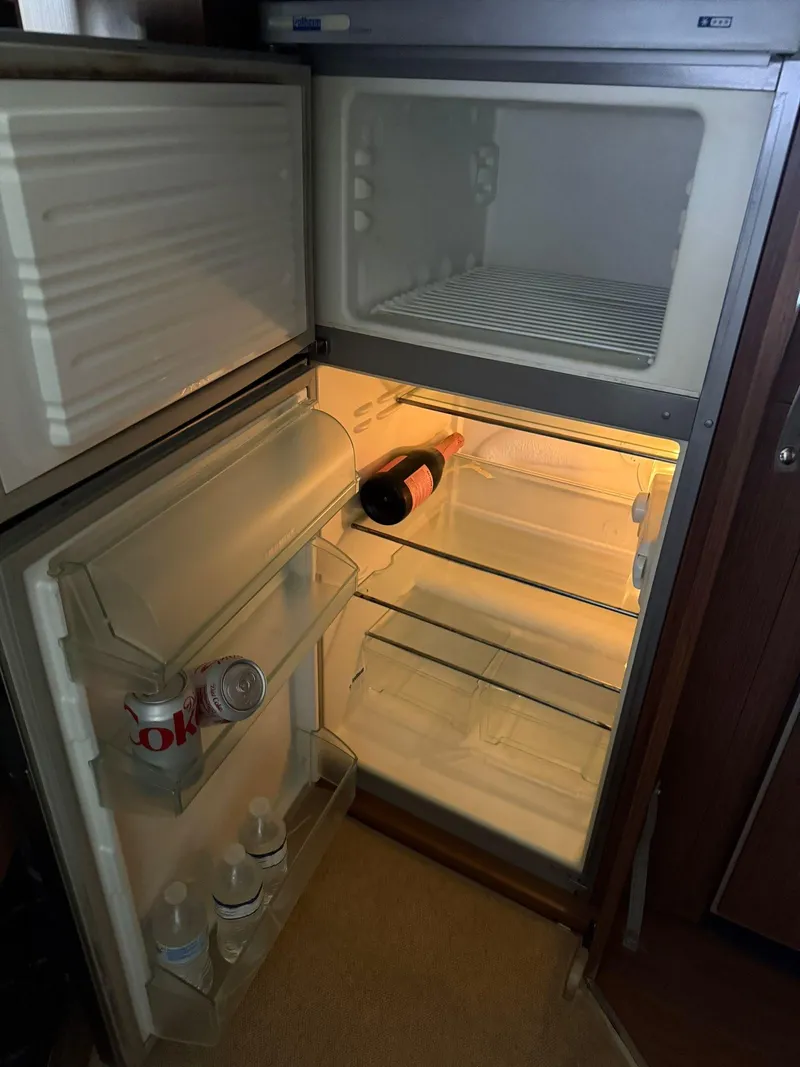 Slide: The Image of Open fridge in a 2012 Riva Rivale, containing drinks and a wine bottle. - 53