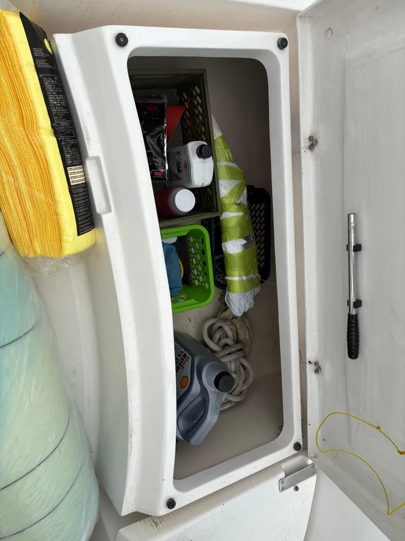 Slide: The Image of Storage compartment on a 1997 Hunter 310 boat, containing supplies and equipment. - 13
