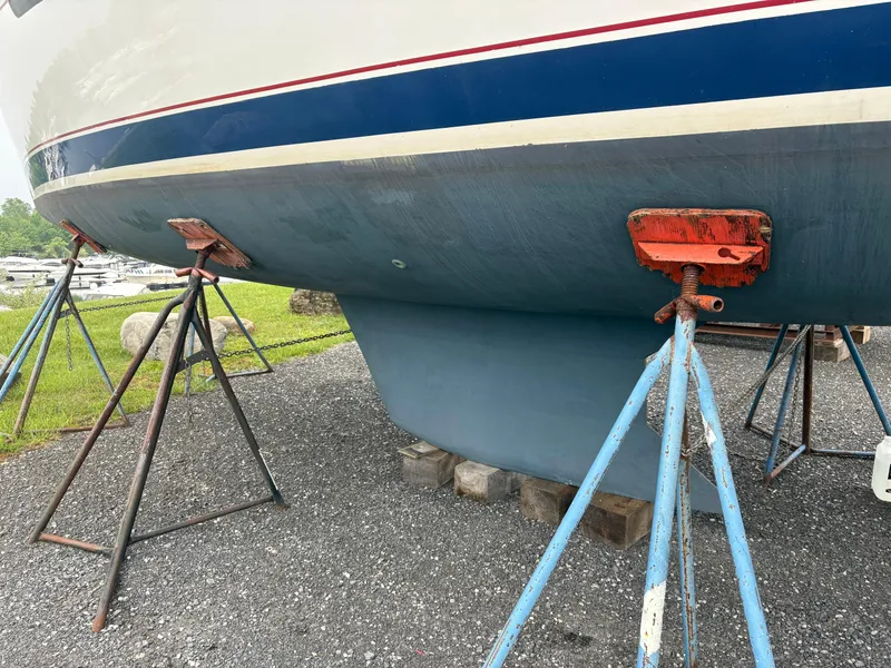 Slide: The Image of 1997 Hunter 310 sailboat on stands, hull view, outdoor storage. - 5