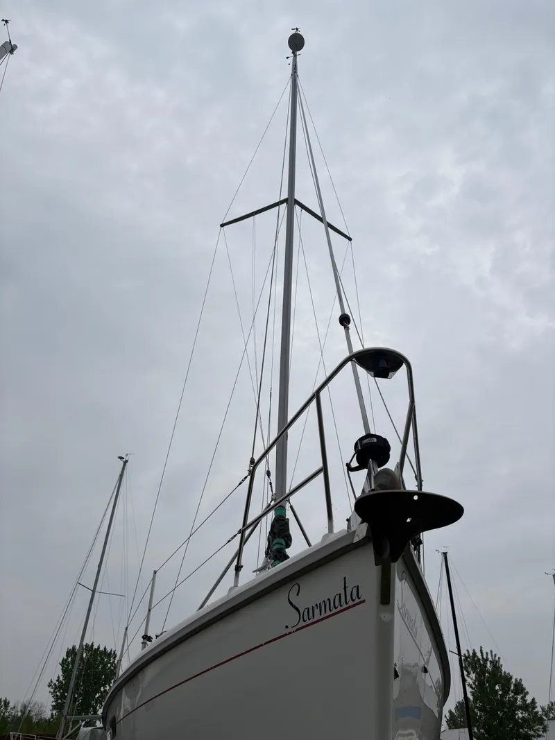 Slide: The Image of Hunter 310 sailboat from 1997 with tall mast against cloudy sky. - 8