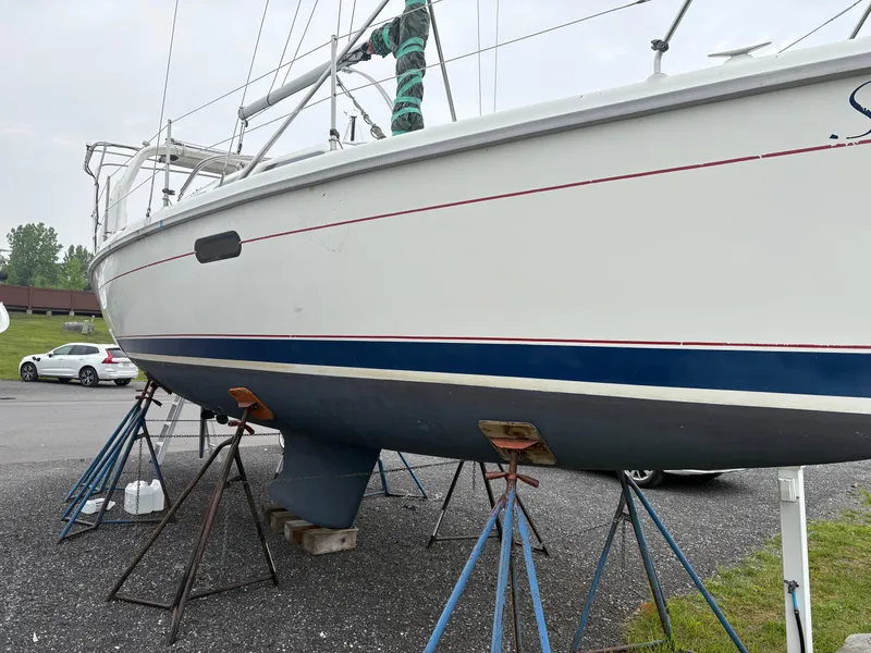 Slide: The Image of Hunter 310 sailboat from 1997 on stands in a parking lot. - 9