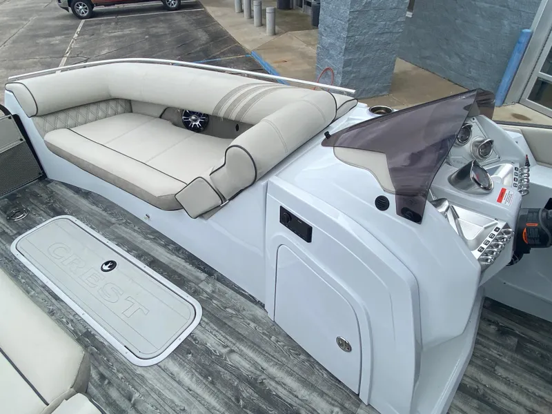 Slide: The Image of 2020 Crest Savannah 250 SLRC boat interior with beige seating and modern dashboard. - 27