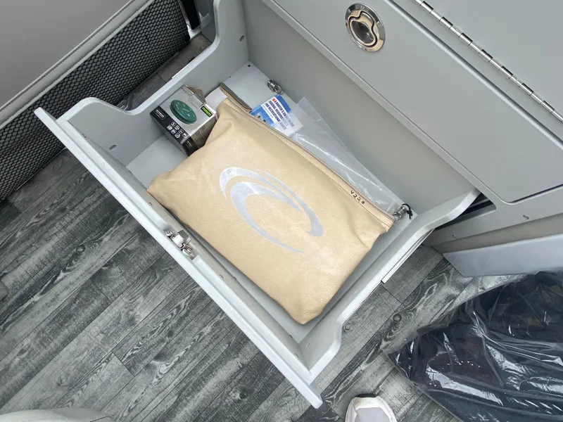 Slide: The Image of Open drawer on 2020 Crest Savannah 250 SLRC boat with pouch and items inside. - 29