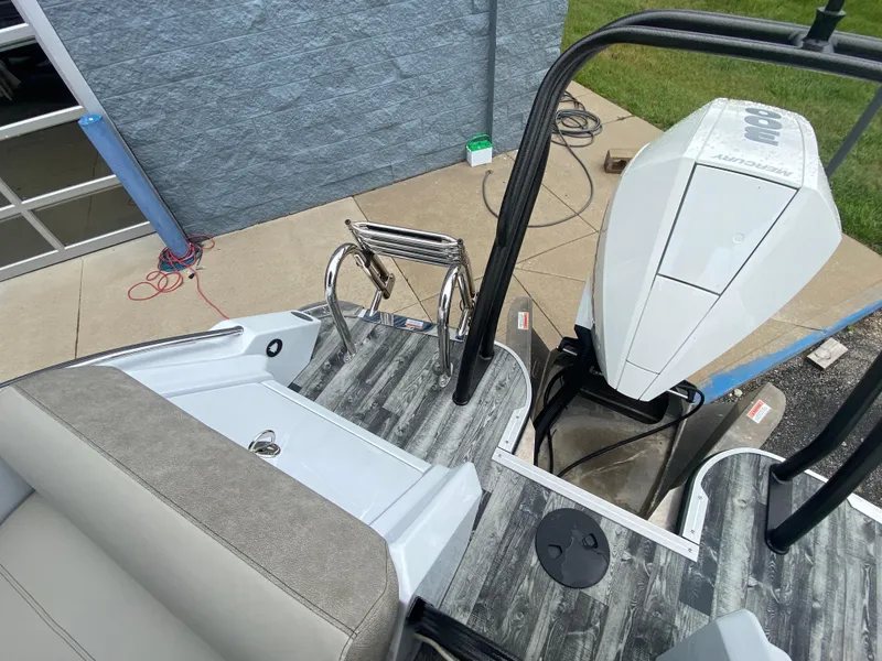 Slide: The Image of 2020 Crest Savannah 250 SLRC boat with outboard motor and seating, docked on concrete. - 34
