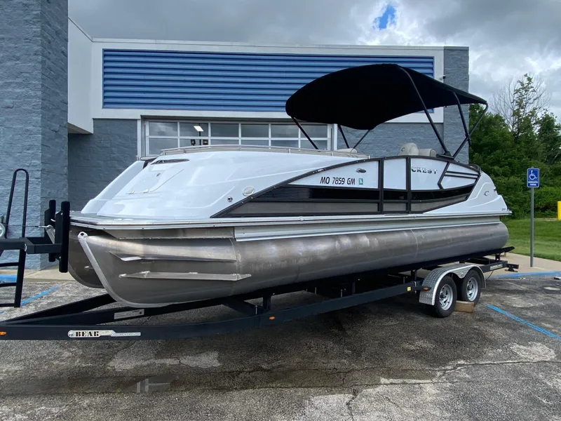 Slide: The Image of 2020 Crest Savannah 250 SLRC pontoon boat on trailer, parked outdoors. - 39