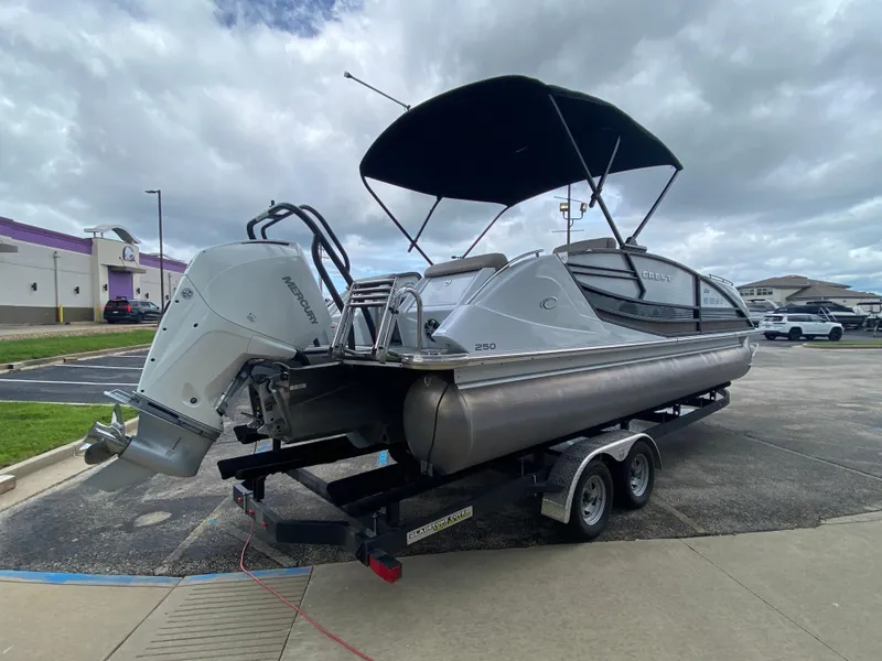 Slide: The Image of 2020 Crest Savannah 250 SLRC pontoon boat on trailer, parked outdoors under cloudy sky. - 41