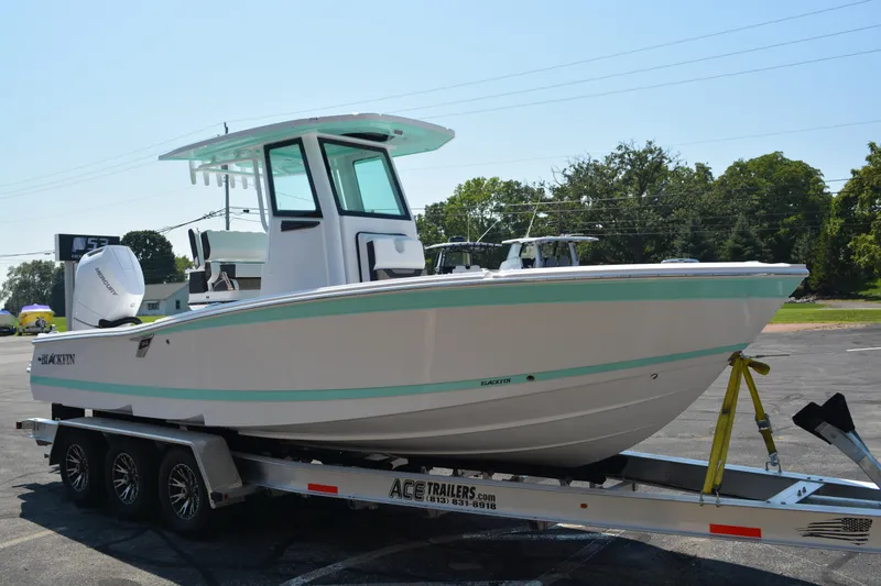 Slide: The Image of 2026 Blackfin 262 HB boat on trailer, parked outdoors, side view. - 1