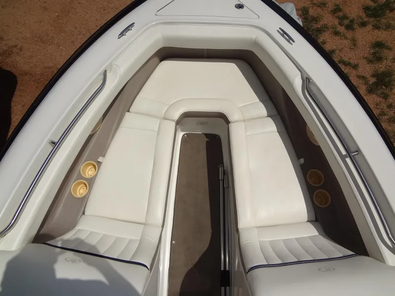 Slide: The Image of 2004 Cobalt 240 boat interior with white seating and cup holders. - 10