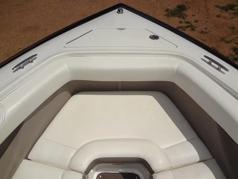 Slide: The Image of 2004 Cobalt 240 boat bow with white cushioned seating and storage compartment. - 11