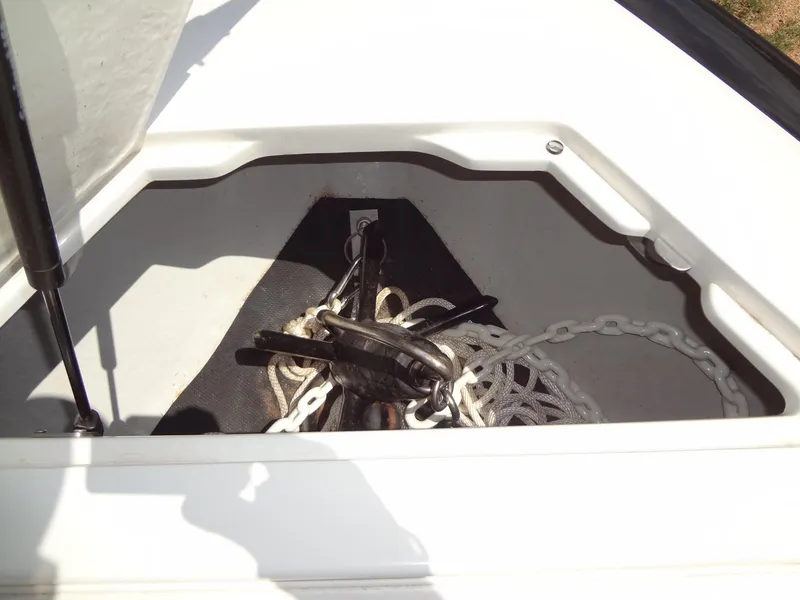 Slide: The Image of Anchor storage compartment on a 2004 Cobalt 240 boat, featuring chain and rope. - 12