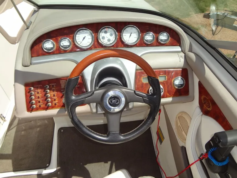 Slide: The Image of Dashboard of a 2004 Cobalt 240 boat with wood accents and steering wheel. - 14