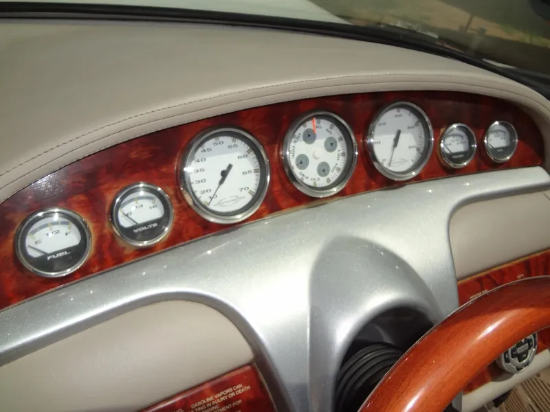 Slide: The Image of Dashboard of a 2004 Cobalt 240 boat with wood trim and multiple gauges. - 16