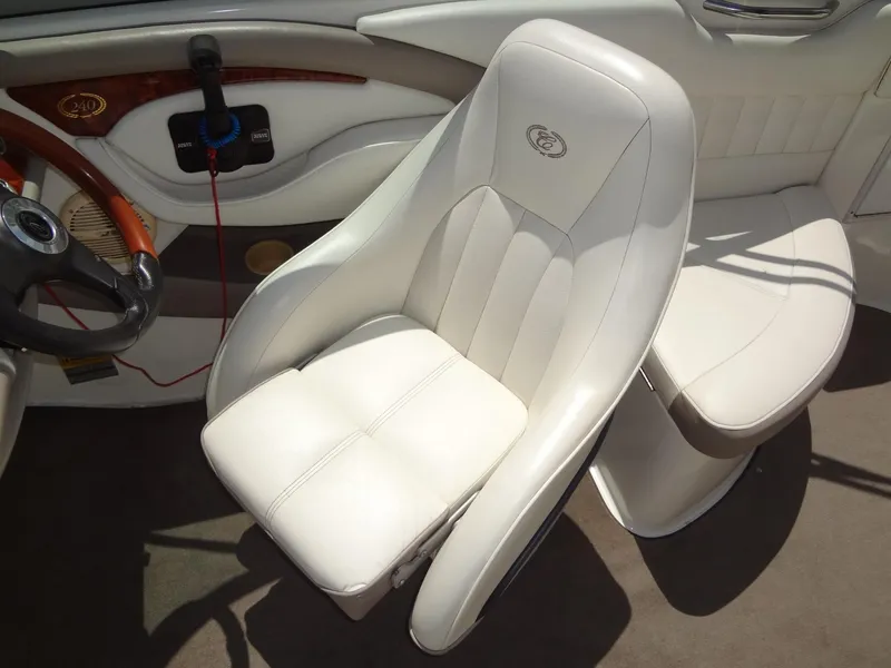 Slide: The Image of 2004 Cobalt 240 boat interior with white leather seating and wooden steering accents. - 18