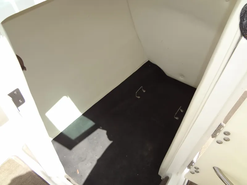 Slide: The Image of Storage compartment in a 2004 Cobalt 240 boat, featuring a clean, spacious interior. - 20