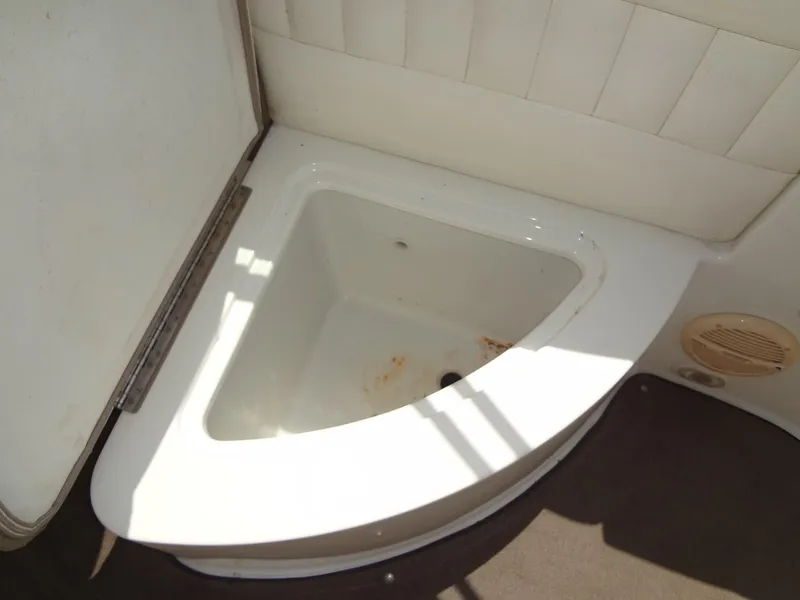 Slide: The Image of 2004 Cobalt 240 boat interior with open storage compartment. - 25