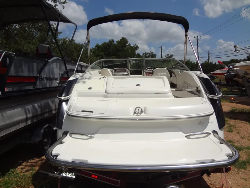 Slide: The Image of 2004 Cobalt 240 boat with open deck, parked outdoors under a blue sky. - 3
