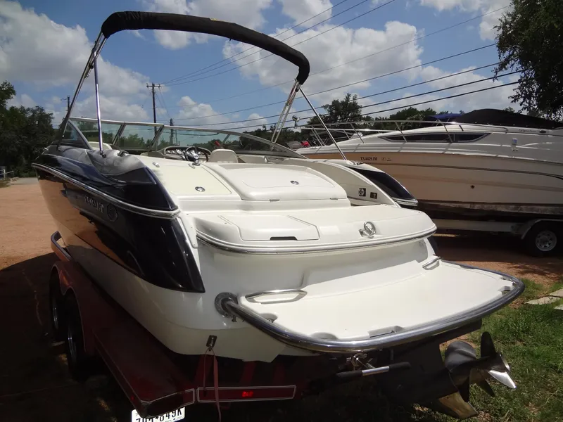 Slide: The Image of 2004 Cobalt 240 boat on trailer, rear view, sunny day, parked near other boats. - 4